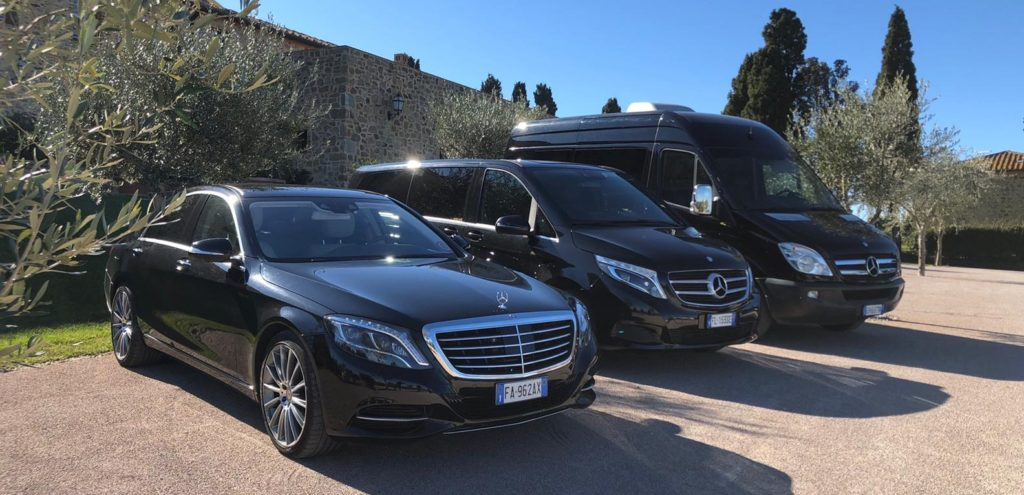 Automobili e van Mercedes di Ls Car Rent disponibili per il noleggio auto con conducente parcheggiate una accanto all'altra vicino a un podere tipico toscano